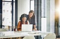 Inspiring innovation with their every move. two businesswomen working together on a laptop in an office.