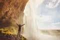 Inspiring travel landscape, person standing near beautiful waterfall