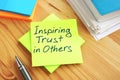 Inspiring Trust in Others written by hand on a page. Work in team concept