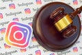 Instagram paper logo lies with wooden judge gavel. Entertainment lawsuit concept