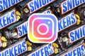 Instagram paper logo on many Snickers chocolate covered wafer bars in brown wrapping. Advertising chocolate product in Instagram