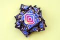 Instagram paper logo on many Snickers chocolate covered wafer bars in brown wrapping. Advertising chocolate product in Instagram
