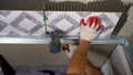 Instaling ceramic tiles. Male hands glue ceramic tiles on the wall in the bathroom. Royalty Free Stock Photo