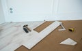 Install floor by yourself. Picture of wood flooring or laminate and tools against white wall