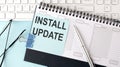 INSTALL UPDATE text on blue sticker on planning and keyboard,blue background Royalty Free Stock Photo