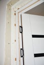 Installation of a black and white laminate internal interior door by attaching door installation brackets and hinges to the