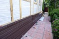 Installation of brown plastic siding on the facade