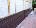 Installation of brown plastic siding on the facade