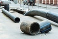 Installation of the city sewerage system. Large diameter plastic pipes lie on the asphalt near the trench. Foreground