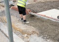 Installation of edging pin kerb on semi-dry concrete during footpath construction on new housing development construction site Royalty Free Stock Photo