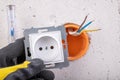 Installation of the electric socket in a rough wall. Installation of a new electrical network at home Royalty Free Stock Photo