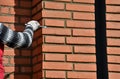 Installation of fired brick cladding. after gluing to the wall, the joints are filled with cement. the worker strokes with the hel