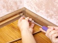 Installation and fixing of the baseboard,mounting and assembly plinth,the master screws the skirting board closeup