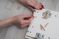 A woman inserts wooden pins into the sidewall of the furniture w Royalty Free Stock Photo