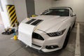 Installation gluing, applying of black strips decal of glossy black foil on a white sports muscle car