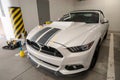 Installation gluing, applying of black strips decal of glossy black foil on a white sports muscle car