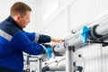 Installation of industrial water treatment system. Man in overalls is adjusting indoor water supply system. Royalty Free Stock Photo