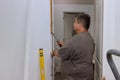 During the installation of interior doors in a new house, a trim carpenter uses the hammer Royalty Free Stock Photo