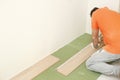 Installation laminate or parquet in the room, worker installing wooden laminate flooring, marking the length of the Royalty Free Stock Photo