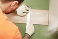 Installation laminate or parquet in the room, worker installing wooden laminate flooring, marking the length of the Royalty Free Stock Photo