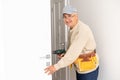 Installation of a lock on the entrance door Hand & x27;s man with screwdriver Installs door knob. Royalty Free Stock Photo