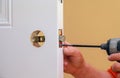 Installation locked interior door knobs, close-up woodworker hands install lock