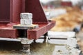 Installation of a metal column for an industrial building. Mounting bolts close-up. Connection of a structure with a reinforced