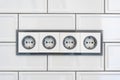 Installation modern sockets on a tile wall close-up. Grey and white electrical outlet.