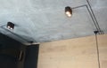 Installation of modern stylish matte black track lighting, small LED ceiling pendant lamps with black cable cords on a gray