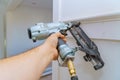 Installation of mouldings on the wall of fragment of molding, top view of carpenter brad using nail gun