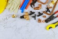 Installation of plastic pipes for the water system, pipe cutting tools, corners, holders, taps, adapters and work gloves on Royalty Free Stock Photo