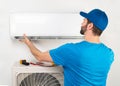 Installation service fix  repair maintenance of an air conditioner indoor unit, by cryogenist technican worker in blue shirt Royalty Free Stock Photo