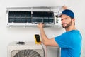 Installation service fix repair maintenance of an air conditioner indoor unit, by cryogenist technican worker checking the air