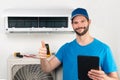 Installation service fix  repair maintenance of an air conditioner indoor unit, by cryogenist technican worker giving thumbs up Royalty Free Stock Photo