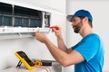 Installation service fix  repair maintenance of an air conditioner indoor unit by cryogenist technican worker with screwdriver Royalty Free Stock Photo