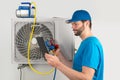 Installation service fix  repair maintenance of an air conditioner outdoor unit, by cryogenist technican worker evacuate the Royalty Free Stock Photo