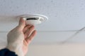 Installation of a smoke detector on the ceiling in the room. Royalty Free Stock Photo