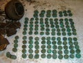 Installation of a treasure of silver coins of the 17th century, a jug with treasures on a light background