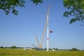 Installation of a wind turbine, high crane lifting the nacelle onto the tower, rotor hub, blades and generator lying on the Royalty Free Stock Photo