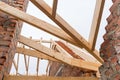 Installation of wooden beams at construction the roof truss system of the brick house. Royalty Free Stock Photo