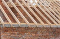 Installation of wooden beams at construction the roof truss system of the brick house. Mauerlat lying on monolithic frame. Royalty Free Stock Photo