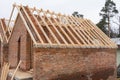 Installation of wooden beams at construction the roof truss system of the brick house. Mauerlat lying on monolithic frame. Royalty Free Stock Photo
