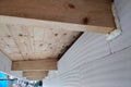 Installation of wooden beams of roof frame with spray foam on a house wall under construction Royalty Free Stock Photo