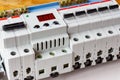 Installed automatic circuit breakers with voltage limiter in the white plastic mounting box closeup Royalty Free Stock Photo