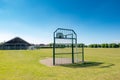 Installed basketball loop seen on a community play-field in early summer.