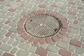 manhole in colored paving slabs Royalty Free Stock Photo