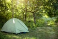 Installed tourist tent in a camping in nature in the forest. Domestic tourism, active summer holidays, family adventures.