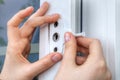 Installer hands close-up, installation of limiter pvc window.