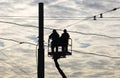 Installers Working on high-altitude workers with cables at height on a background cloudy sky