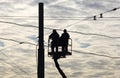 Installers Working on high-altitude workers with cables at height on a background cloudy sky